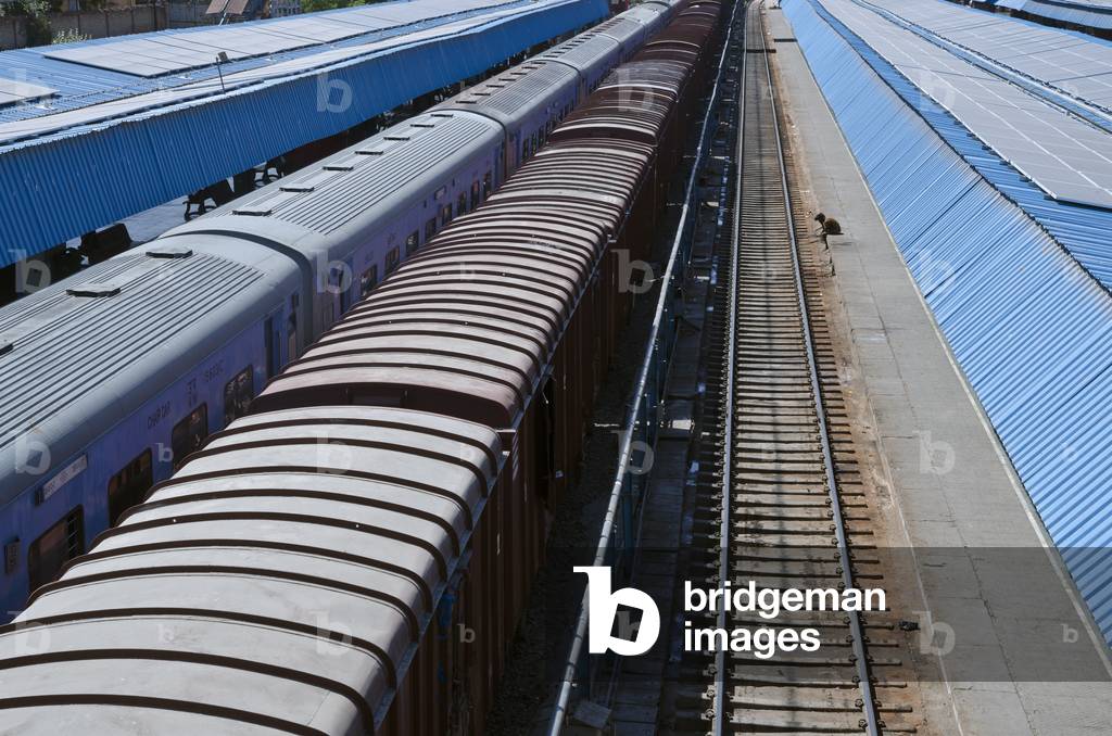 Man sitting on railway station platform dangling feet onto tracks,
Jodhpur, Rajasthan, India (photo)