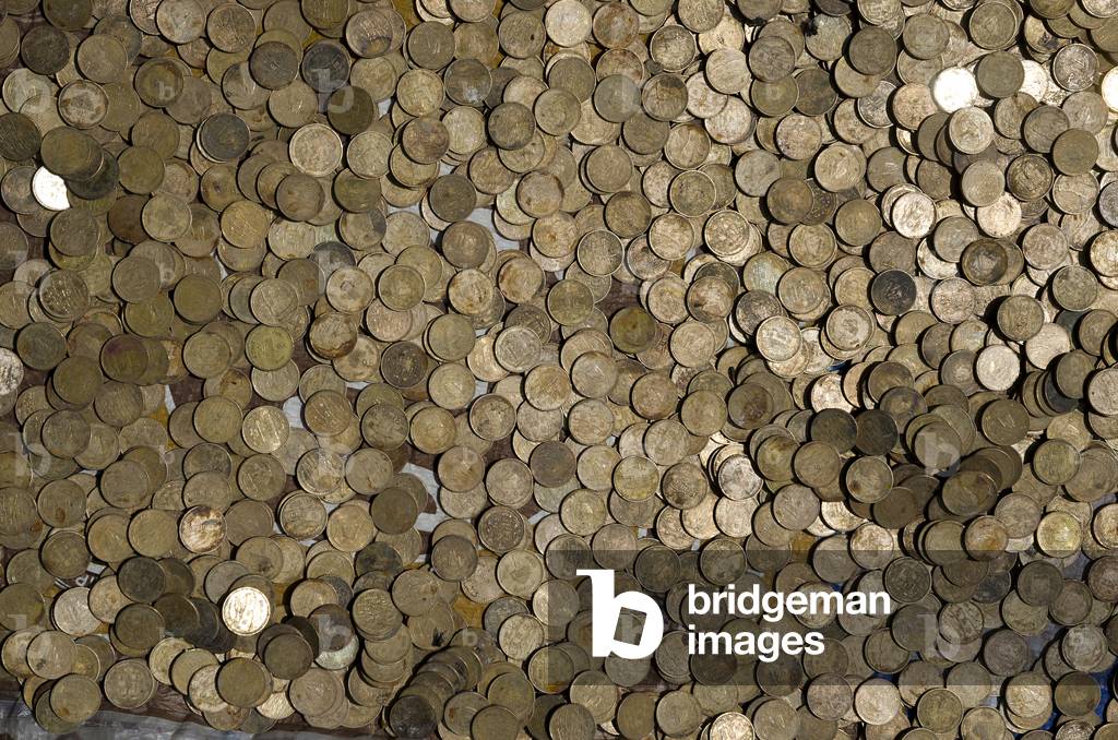 A tray with hundreds of Nepali 1 rupee coins for sale to throw into World Peace Pond nearby Swayambhu (aka. Monkey Temple) complex, Kathmandu, Nepal (photo)