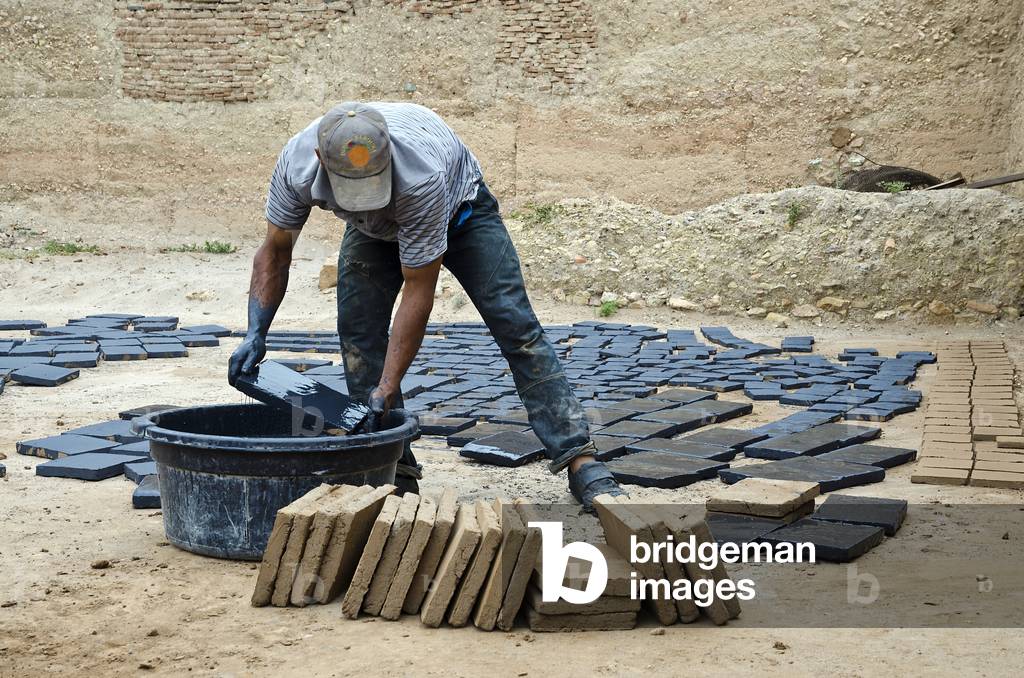 Worker in Berber  village pottery glazing clay tiles, Riad, High Atlas Mountains, Taroudant Province, Morocco (photo)