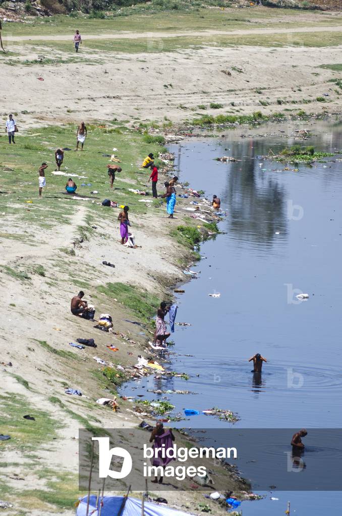 People bathing & washing on the rubbish-strewn Yamuna River bank, nr. Kashmiri Gate, Delhi, India (photo)