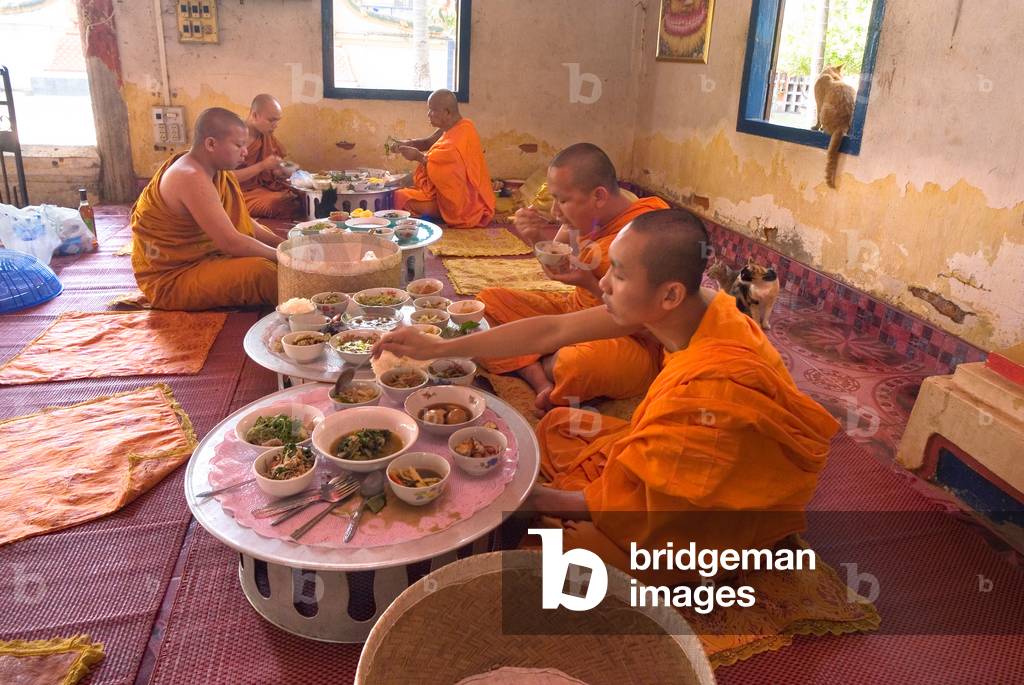 Buddhist monks (Theravada) having main meal (lunch) in temple hall
Khoualuang temple, Vientiane, Laos, Indochina, Southeast Asia