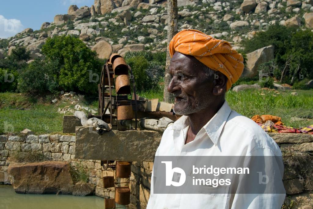 91-year old hill farmer next to persian wheel which he built 65years ago (photo)