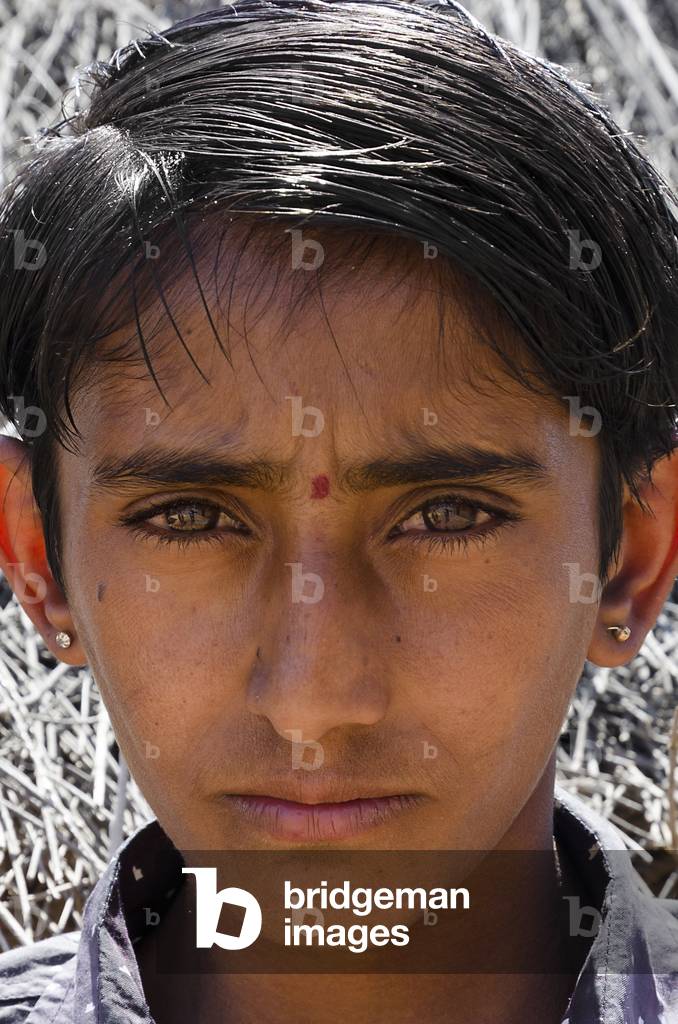 Portrait of an Indian boy with earrings in a Thar Desert hamlet, Bhikhsar, Rajasthan, India (photo)