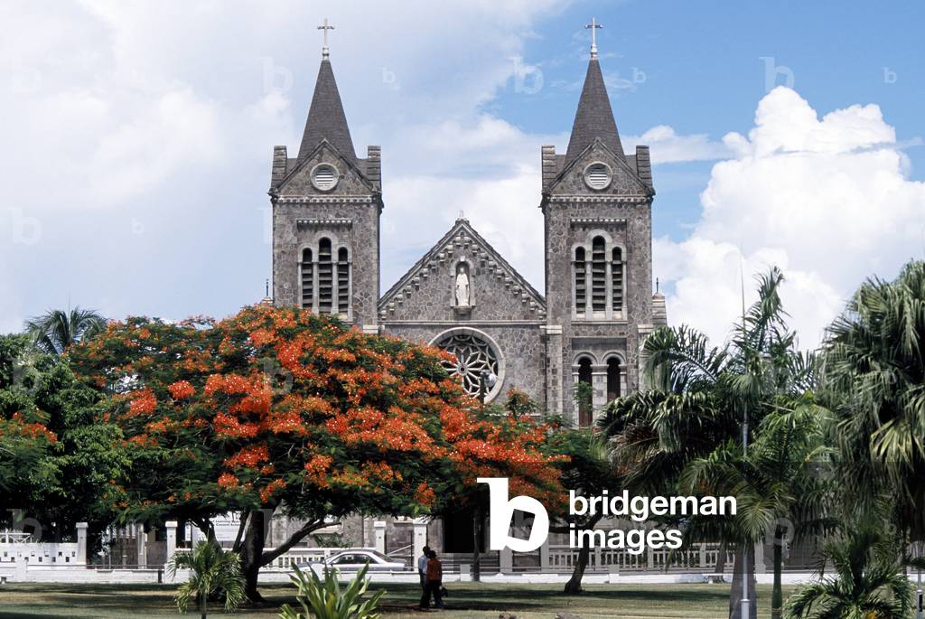 St.Kitts town in Caribbean. Central Square and church with Flamboyant trees. (photo)