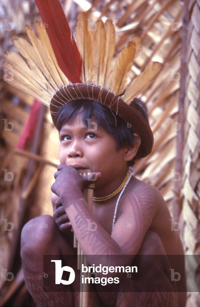 A Makuna boy wearing a feather headdress and playing panpipes, Vaupés department, Colombia, 1960-61 (photo)