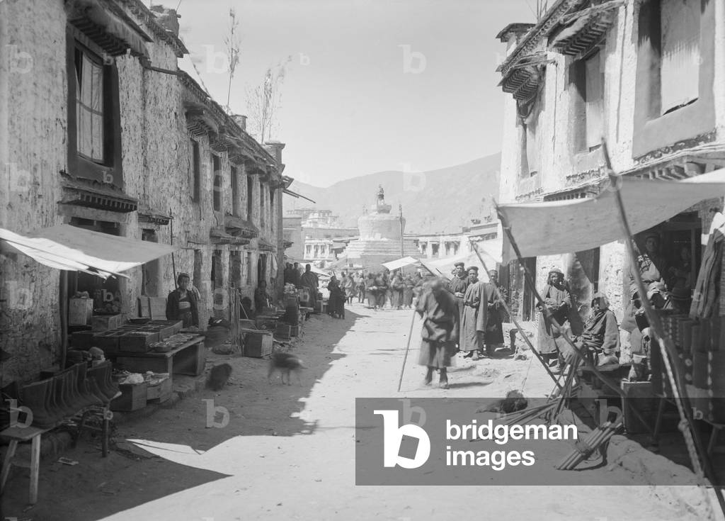 Shops, awnings and prayer flags on top of buildings, possibly on the east side of the Barkhor in central Lhasa, c.1920-21 (glass plate gelatin print)