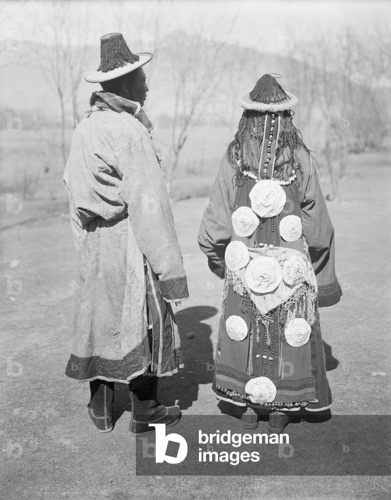 Rear view of a Golok man and his wife, 1921 (glass plate gelatin print)