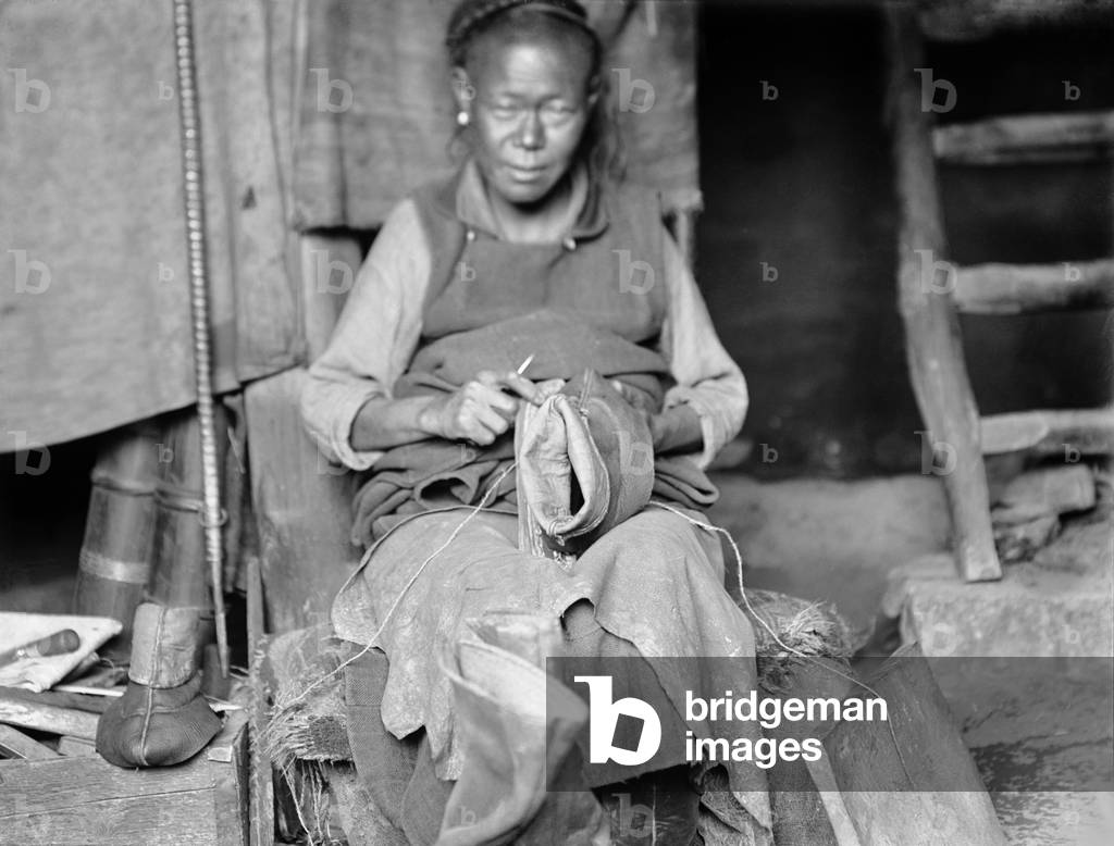 Portrait of a Tibetan cobbler in Lhasa making boots, 1920-21 (negative quarter print)