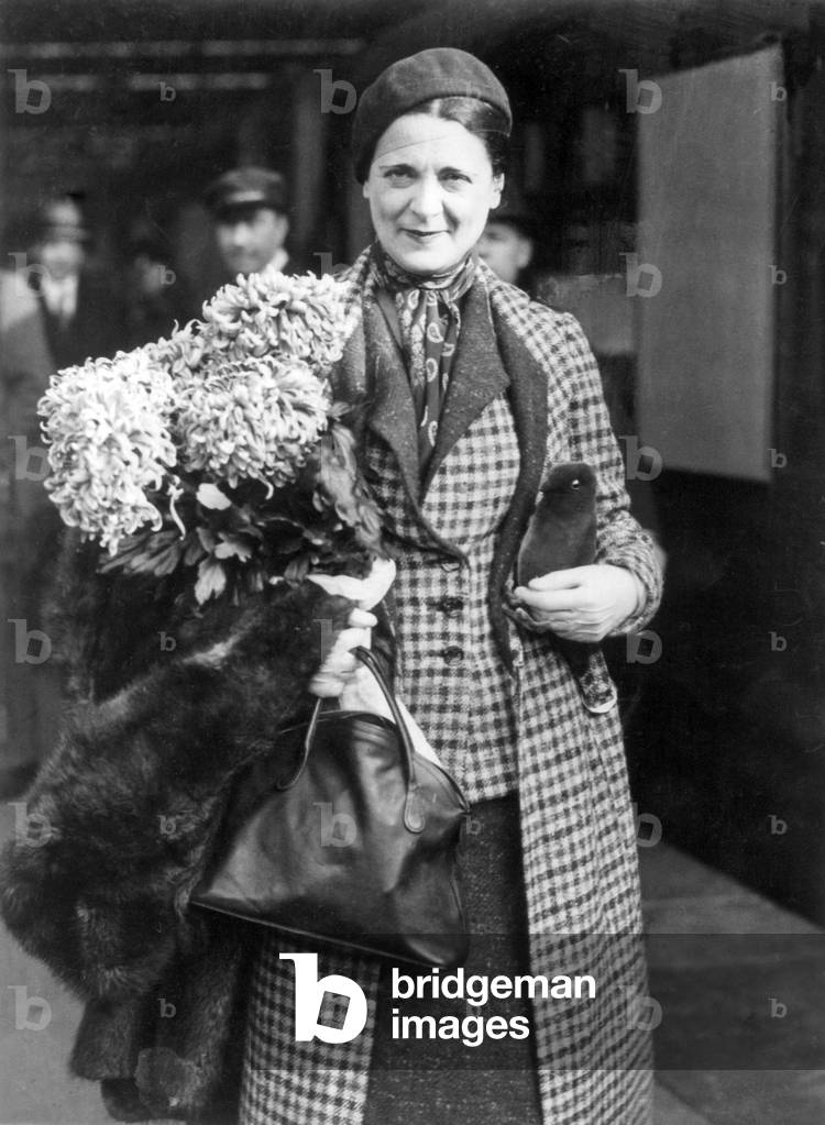Harriet Cohen, English pianist, holding a bouquet of flowers
