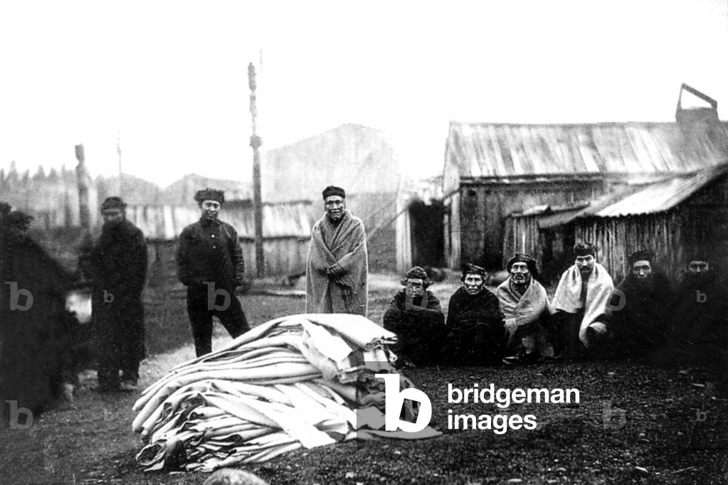 Kwakiutls indians gathered around blanket heap during potlatch ceremony at Fort Rupert before 1895 (b/w photo)