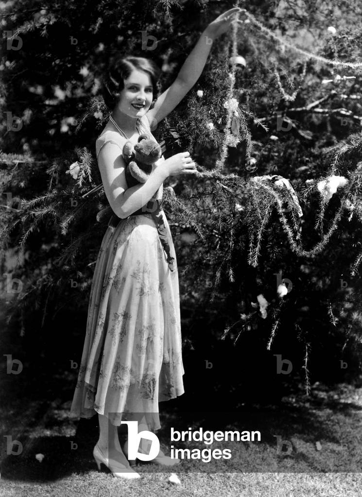 Norma Shearer (1902-1983) american actress putting tinsels in a Christmas tree c. 1925