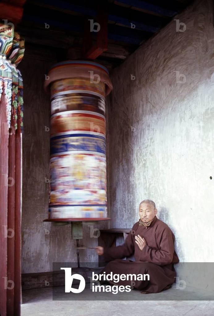 Lama turning prayer wheel, c. 1965-1979 (photo)