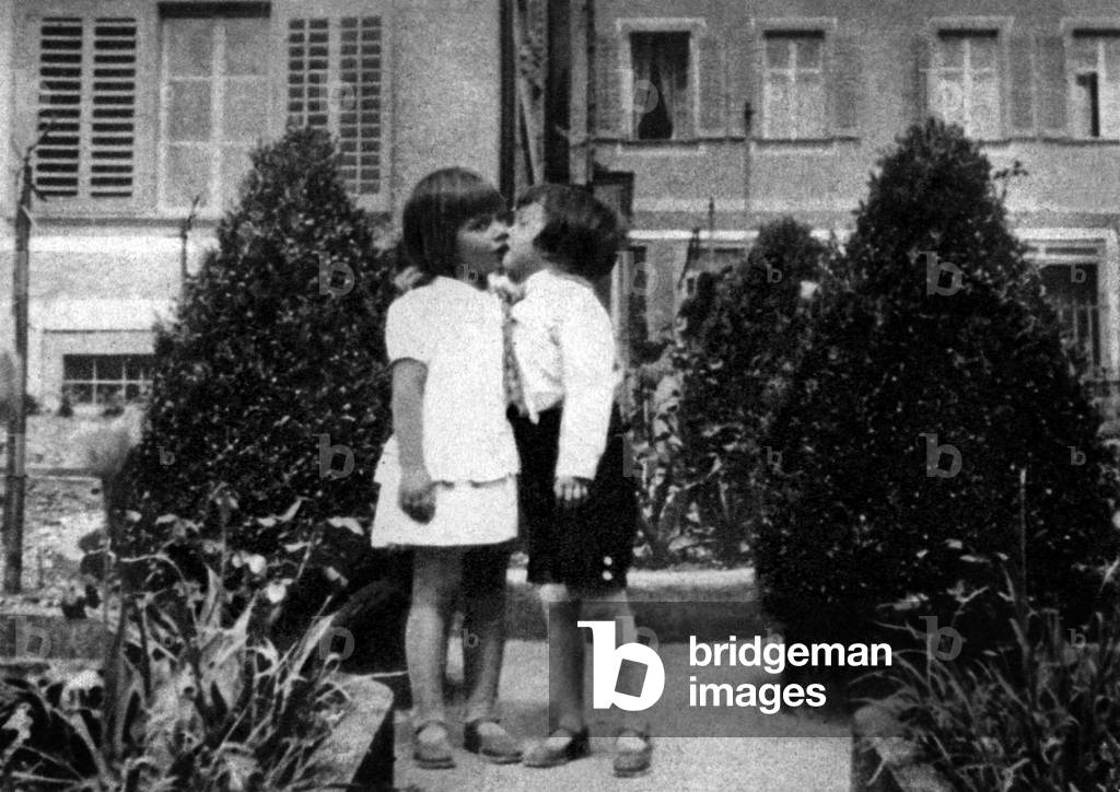 Actress Maria Schell (l), 8 years old, kissing a young neighbour 1934