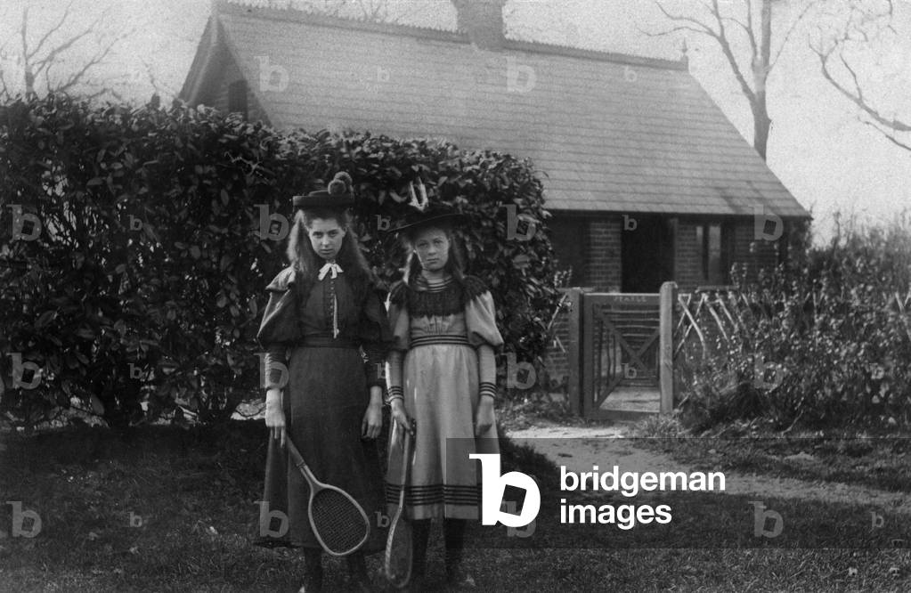 Young girls with rackets in a garden, c. 1900 (photo)