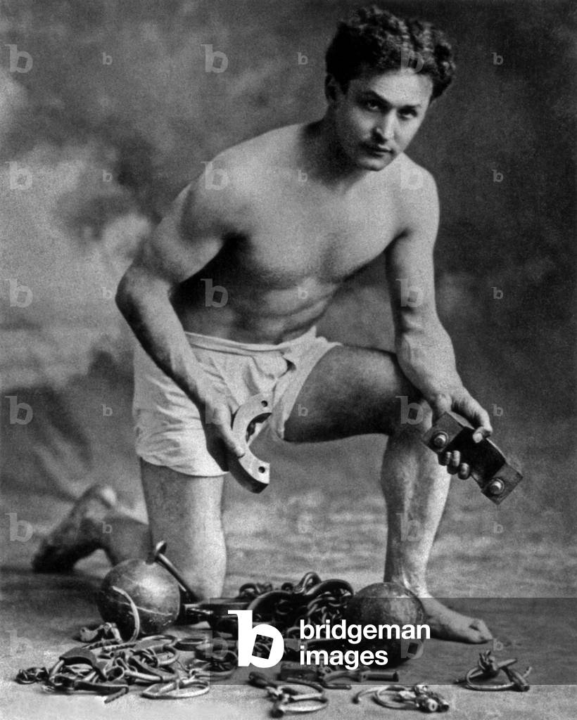 Harry Houdini (1874-1926) american conjuror, here with chains, c. 1906 (photograph)               )