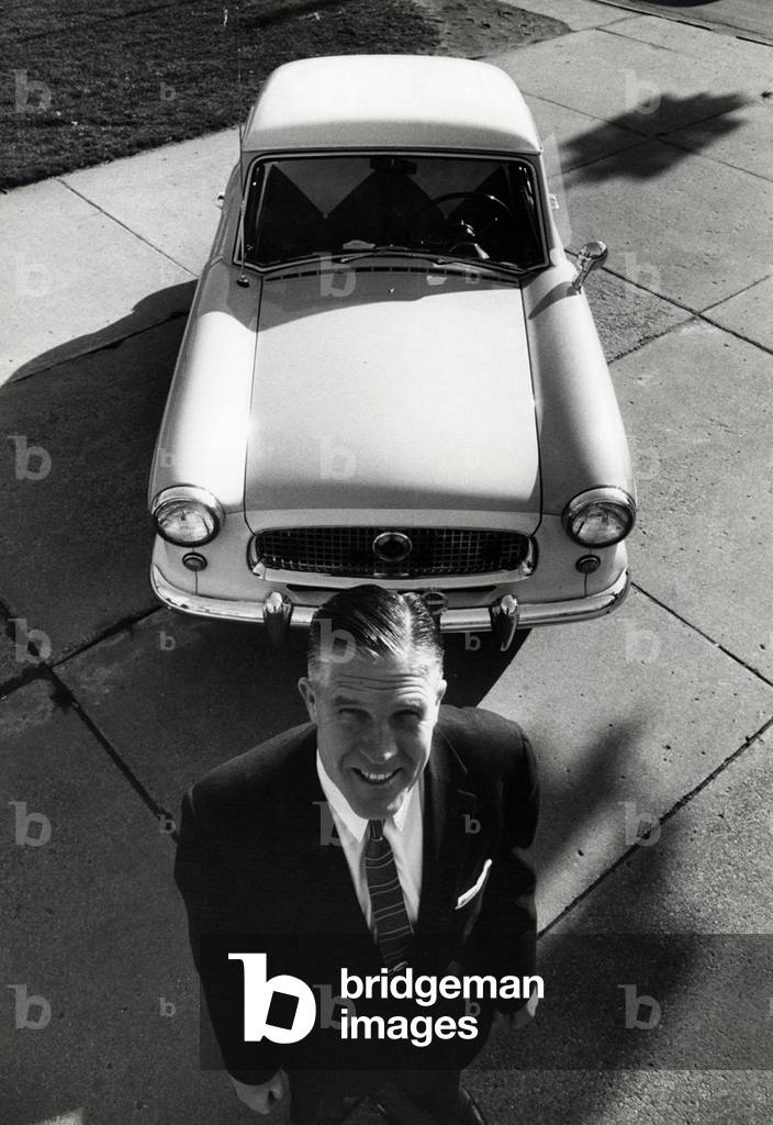 George W. Romney in front of a car 