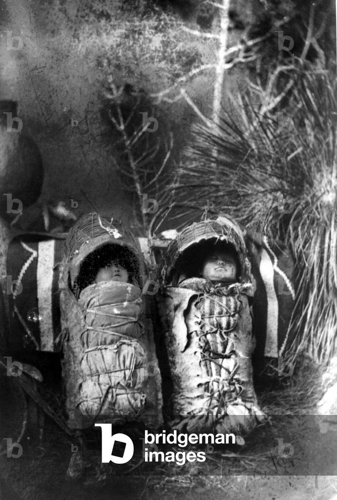 Indian papooses: babies swaddled for not moving, crying and put in structures to be carried in back of adults, c. 1890, north west of USA or Canada, photo by Frank Randall