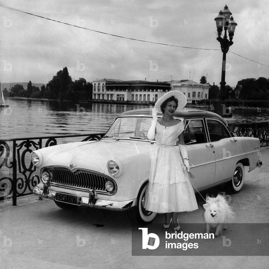 Car exhibition in Enghien les Bains, France, june 23, 1956: cadillac car and elegant woman with a dog