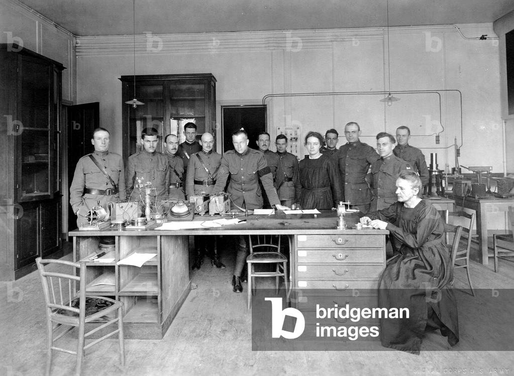 Marie Curie with Irene Curie and surrounded by soldiers and students, 1919 (b/w photo)