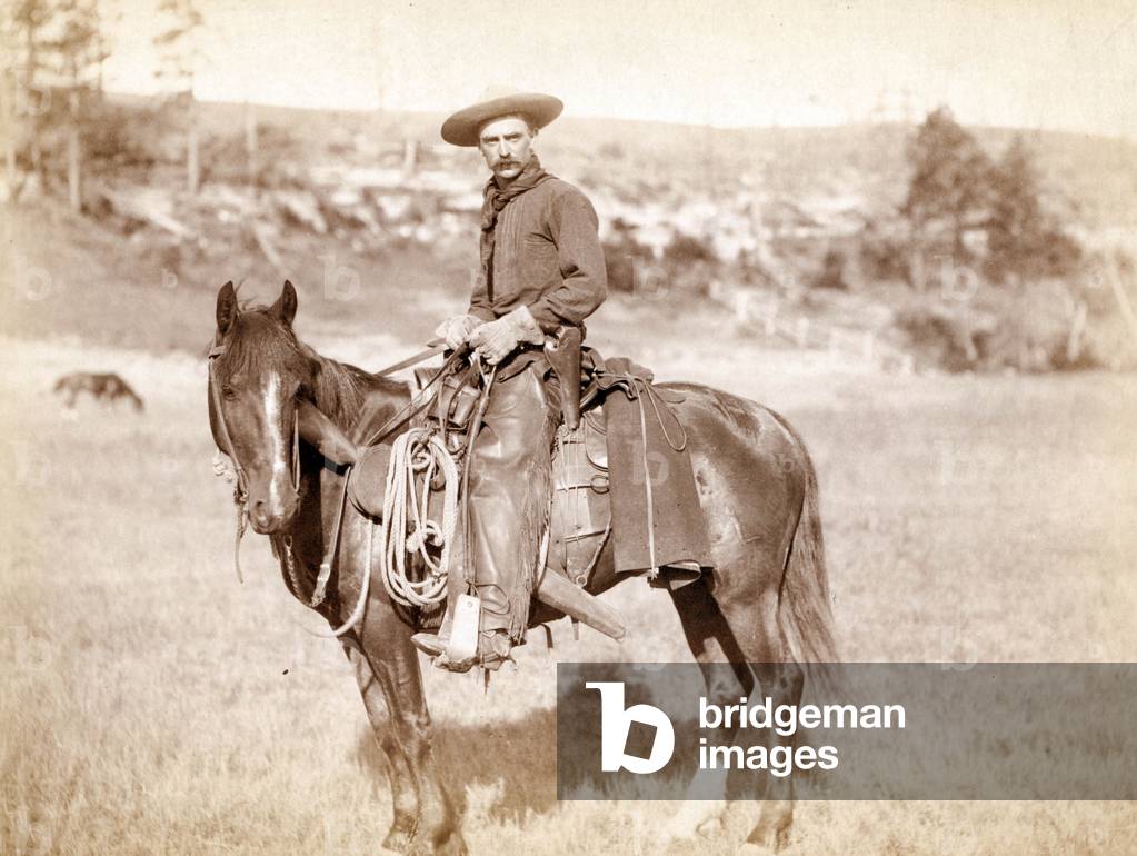 A cow boy on his horsewearing hat, leather trousers (with fringes), lasso, Sturgis, South Dakota, c. 1888, photo by J.C.H. Grabill