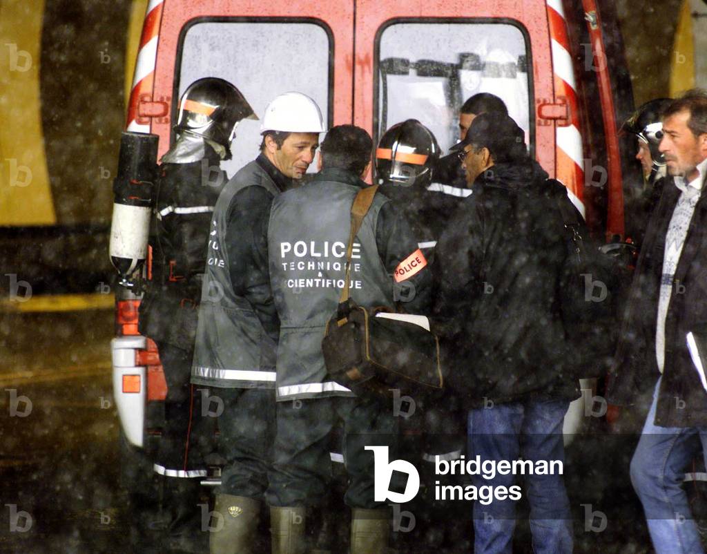 Image of Police forensic scientists arrive at the French entrance to the