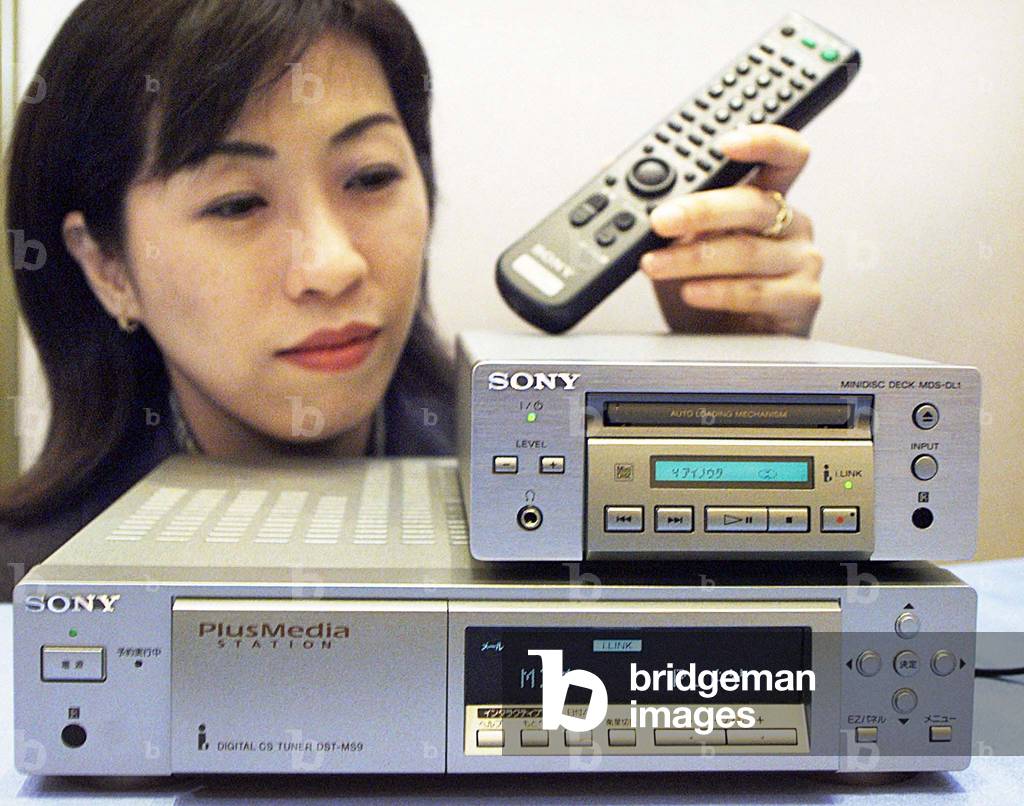 SONY CORP CLERK SHOWS OFF ITS NEW CS DIGITAL BROADCAST RECEIVER AND MINI DISC PLAYER/RECORDER IN TOKYO, 1999-0