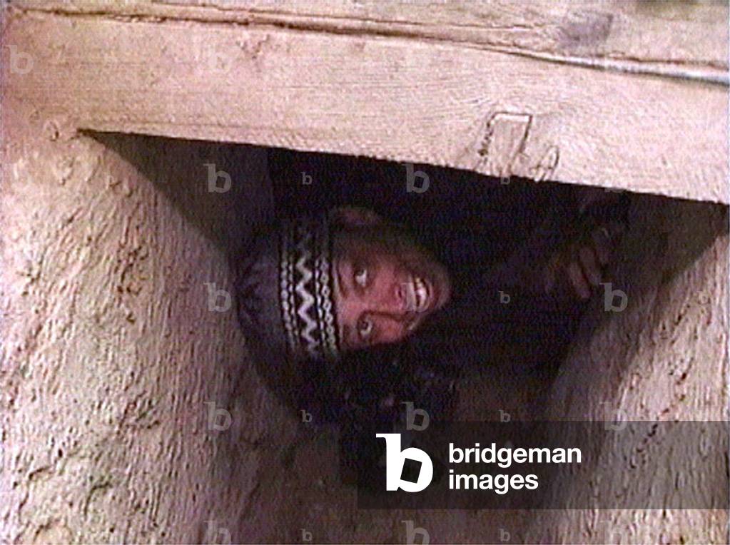 Image of PHOTOGRPAHER PEERS FROM SADDAM HUSSEIN'S SPIDER HOLE NEAR TIKRIT, 2003-12-15