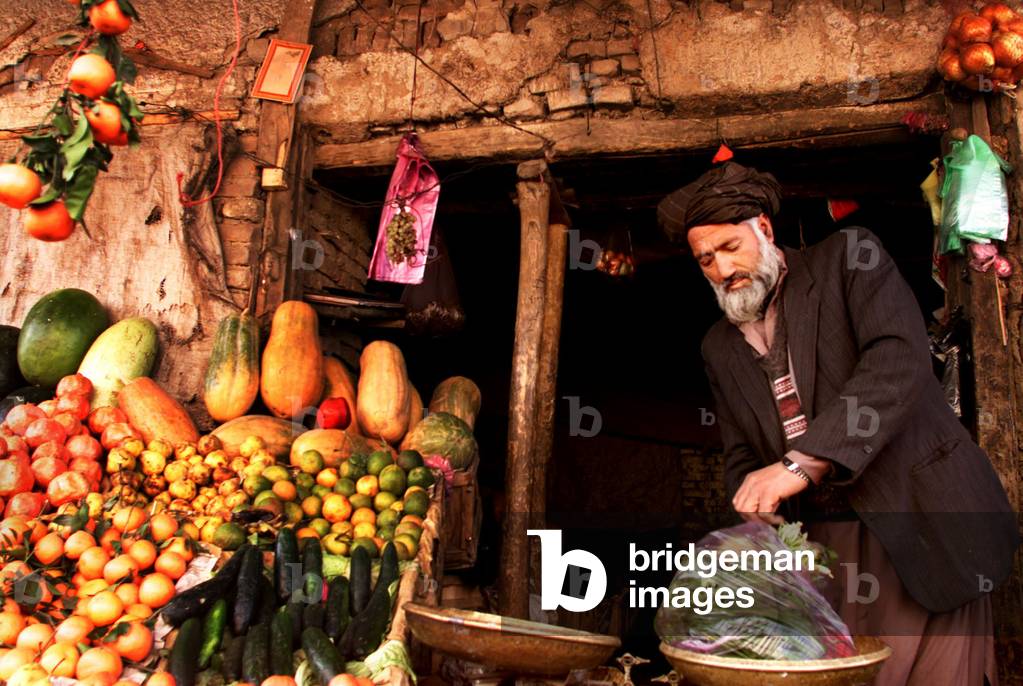 AFGHAN VENDOR WORKS IN HIS SHOP IN CENTRAL KABUL, 2001-12-05 (photo)