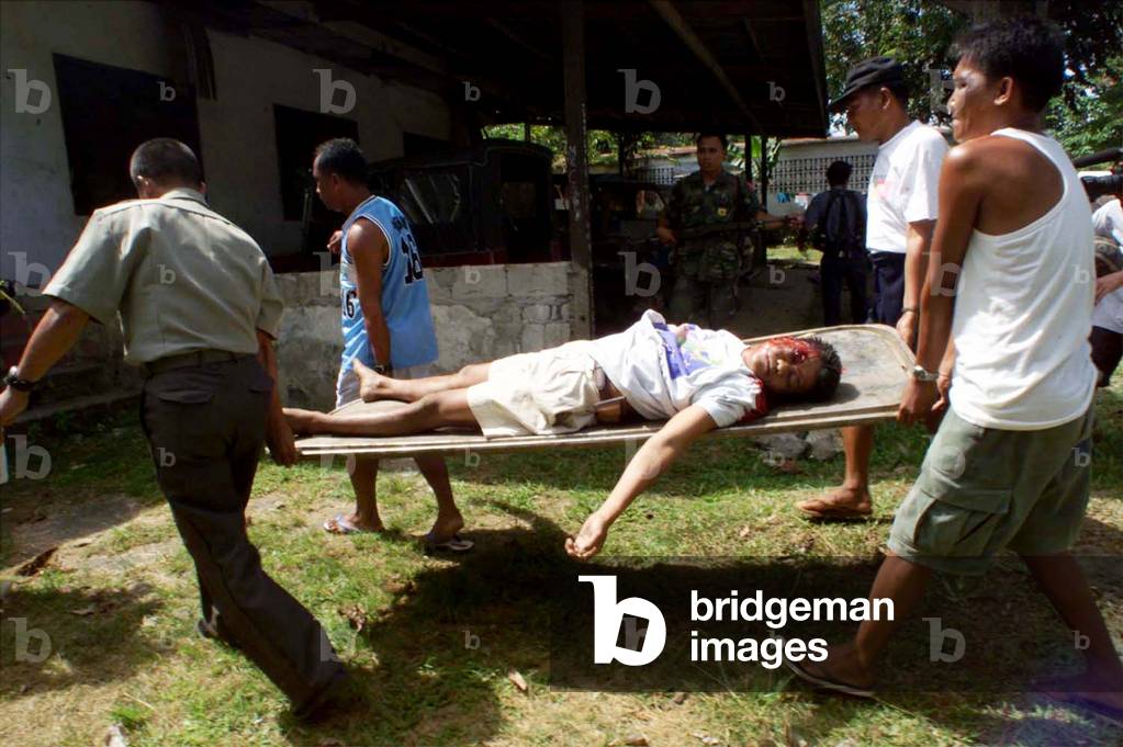FILIPINO POLICEMEN CARRY THE BODY OF SOLDIER ROBERT NAILGA IN JOLO, 2000-05-17 (photo)