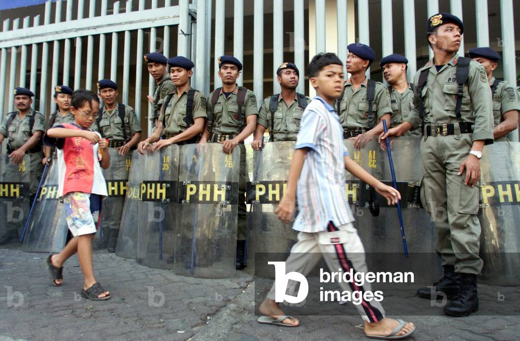 Police Riot Car Children Inaction Image of Indonesian children walk past riot police stationed outside ...
