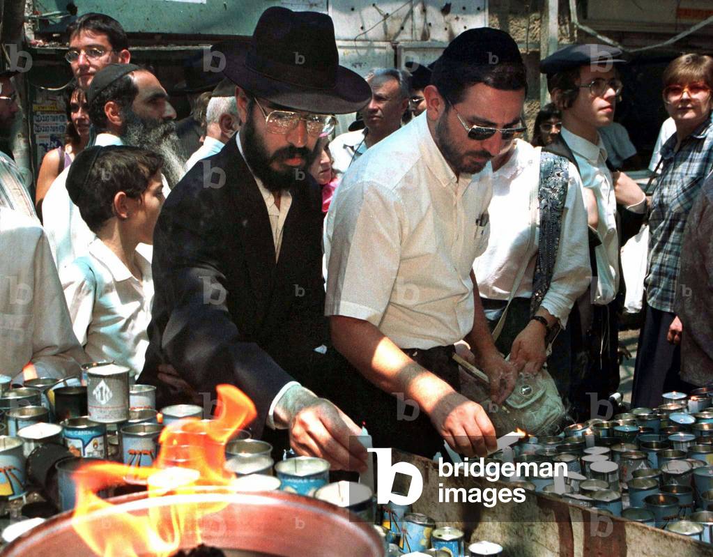 Image of Ultrareligious Jews light memorial candles August 1 for the