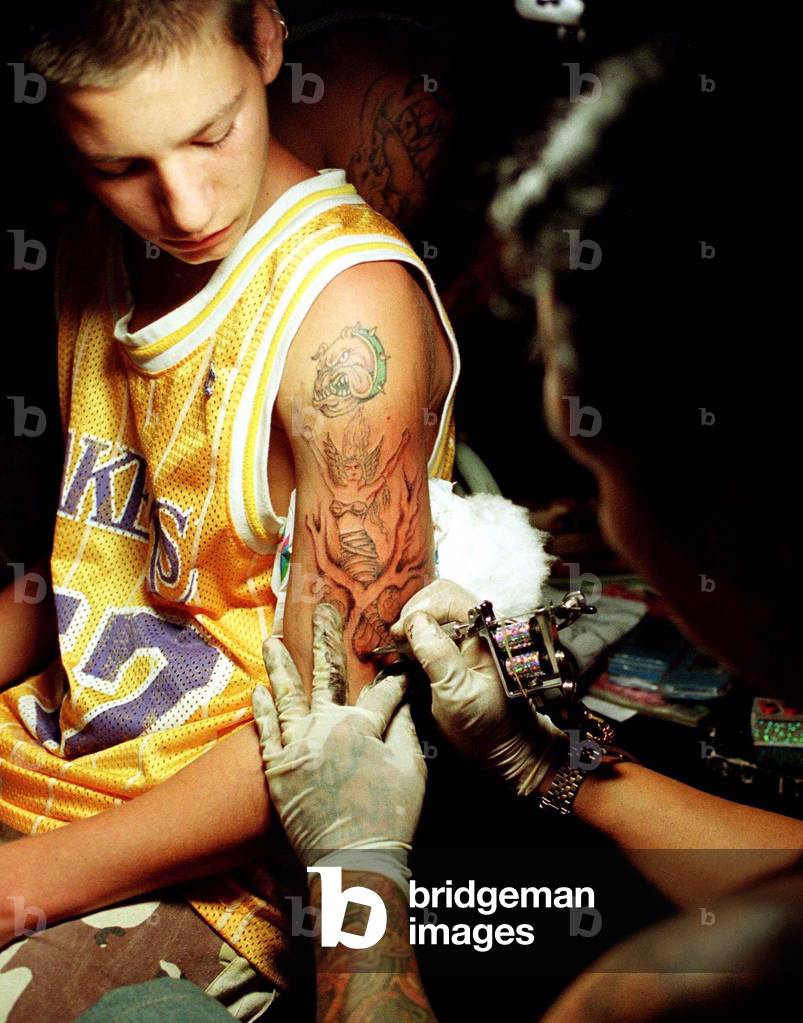 The image of a mermaid is etched on the arm of Swiss national William Beaus, 18, by Filipino tattoo .., 1996-1