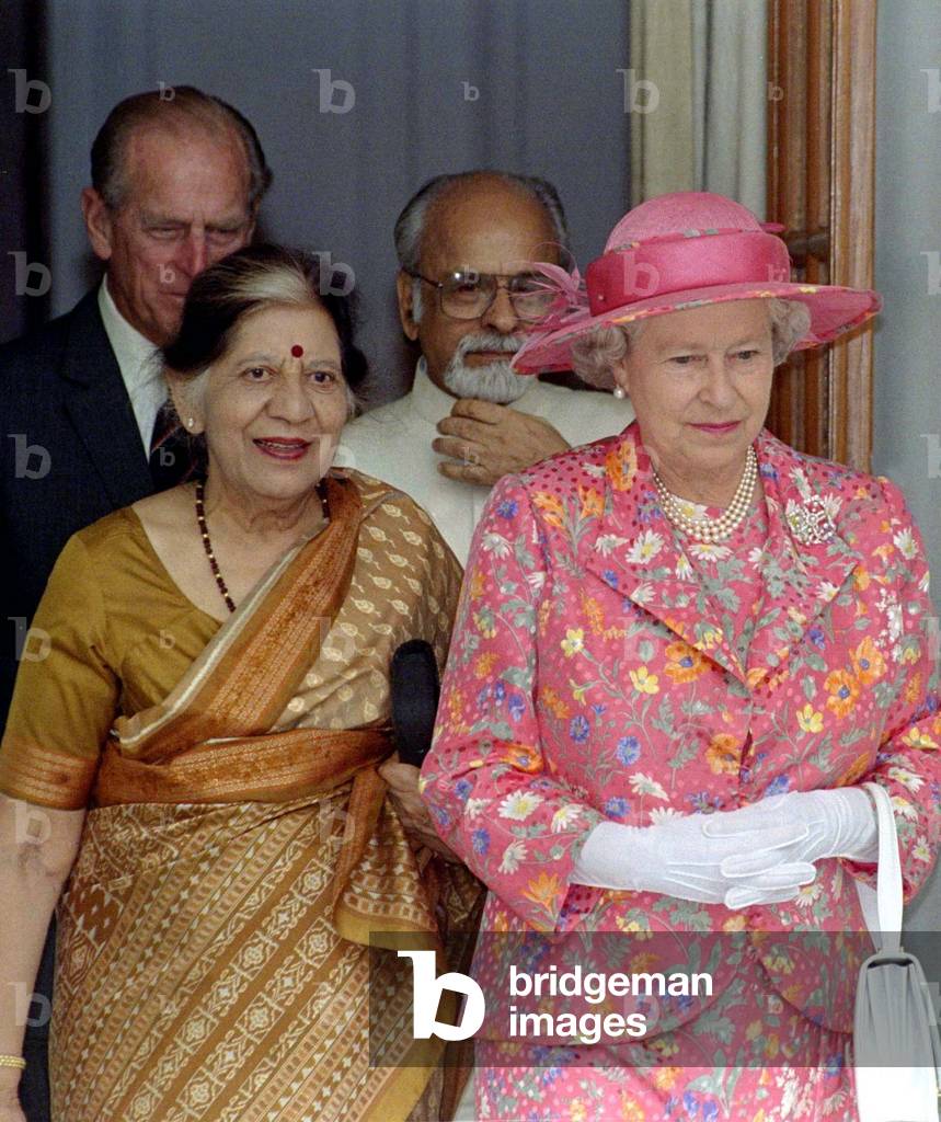 Image of Britain's Queen Elizabeth II (R) and Sheela Gujarl, wife of