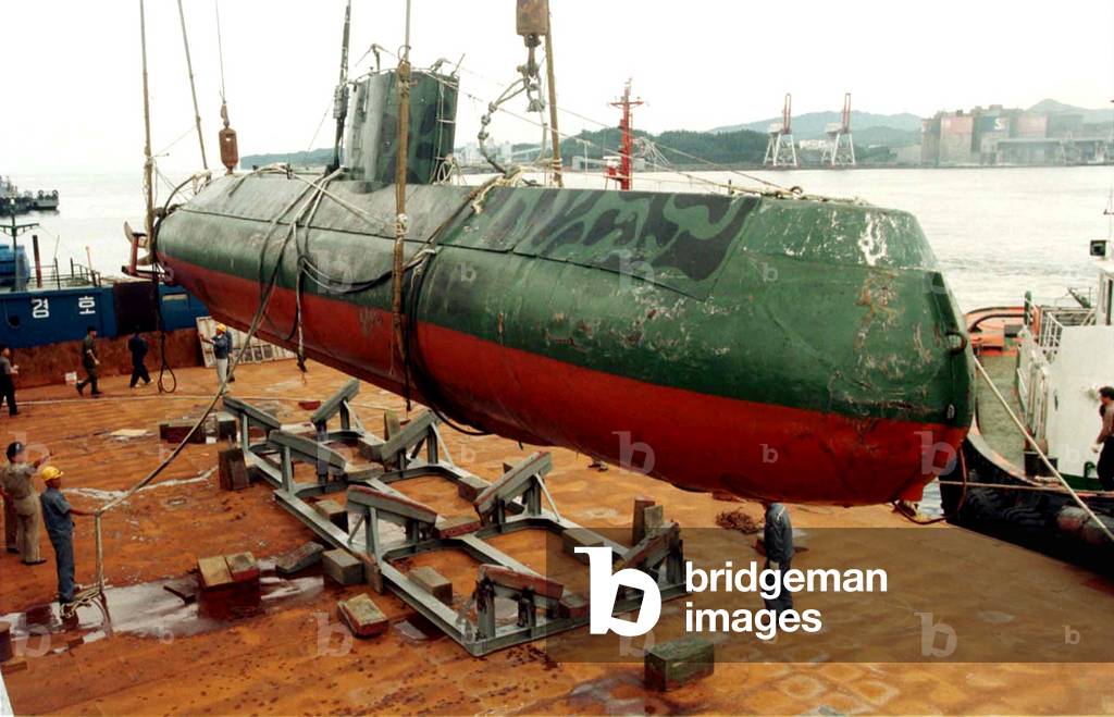 Image of CAPTURED NORTH KOREAN SUBMARINE IS LIFTED ONTO A SHIP AT