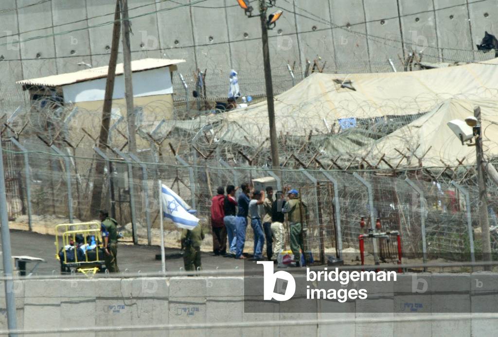 Image of A GROUP OF PRISONERS AWAIT TRANSFER BY ISRAELI SOLDIERS AT