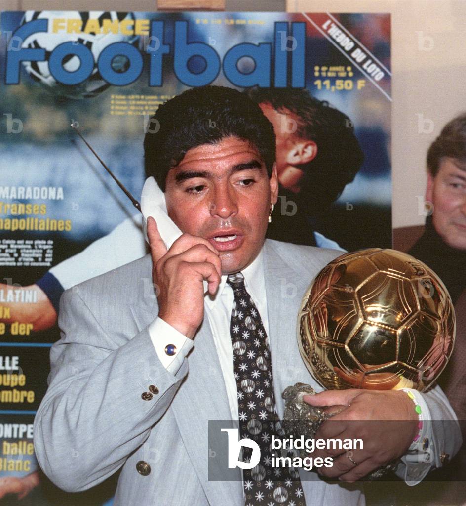 Image of Soccer star Diego Maradona speaks on a portable telephone