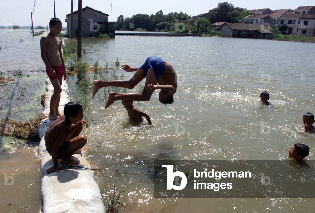 Image of CHINESE BOYS SWIM ON FLOODED RICE FIELDS IN YUEYANG, 2002-08-23