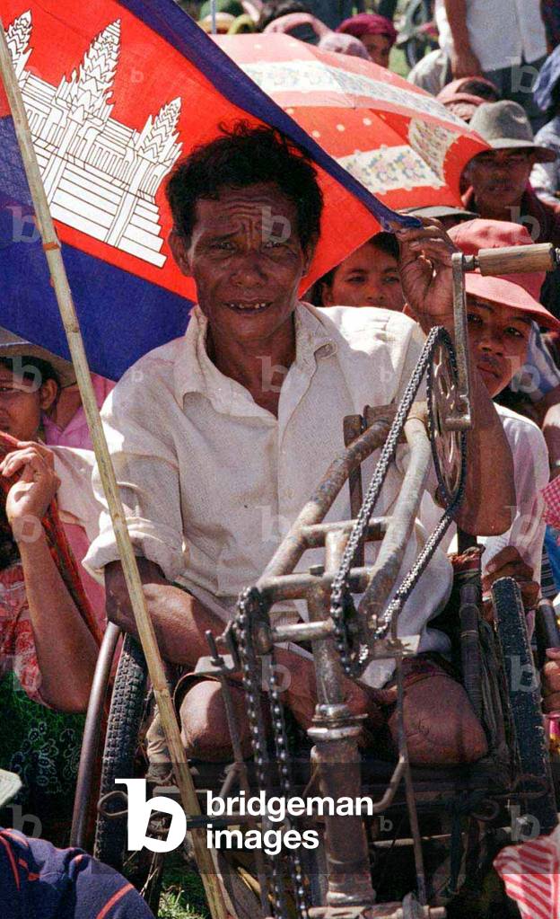 SUPPORTER OF PRINCE RANARIDDH SITS IN HIS WHEELCHAIR IN SIEM REAP, 1998-07-10 (photo)