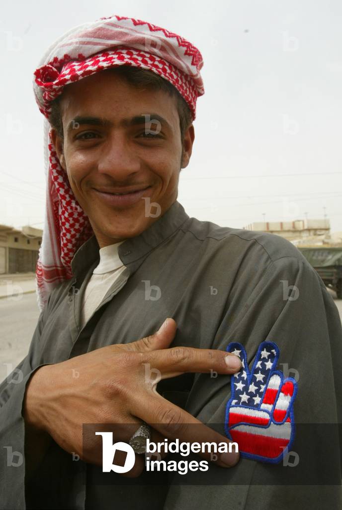 A BOY PROUDLY SHOWS OFF HIS BADGE WITH THE U.S FLAG ON IT AS THE
BRITISH ROYAL AIR FORCE REGIMENT ..., 2003-04