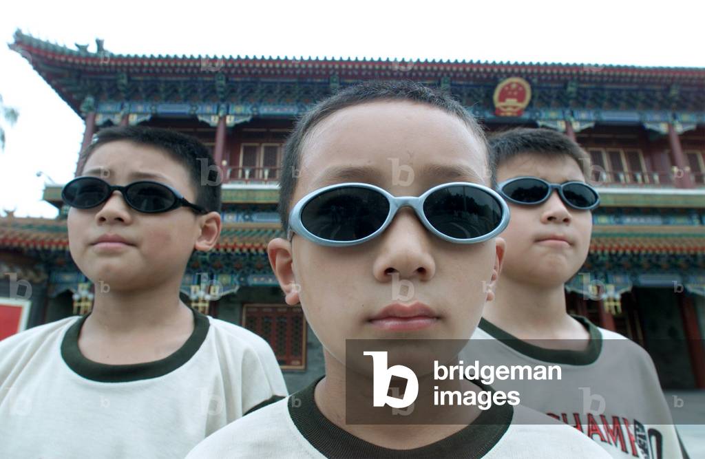 Image of TROIS JEUNES FRÈRES CHINOIS POSENT POUR UNE PHOTO À PÉKIN,