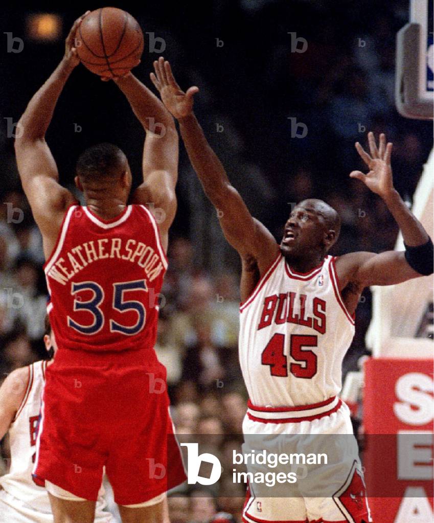 Image of Chicago Bulls' Michael Jordan leaps to block a shot by