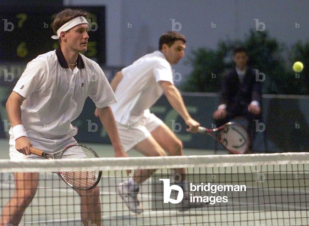 Image of STEFANO PESCOSOLIDO RETURNS A BALL AS LAURENCE TIELEMAN LOOKS ON,
