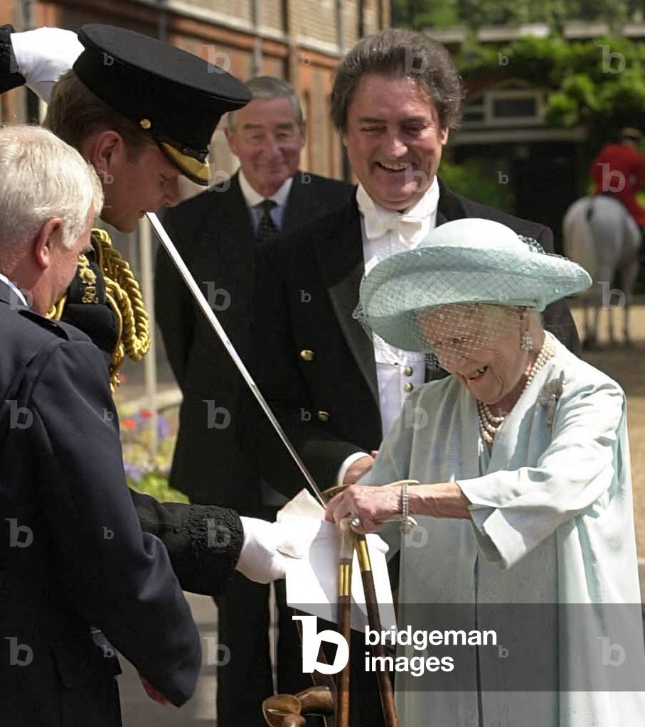THE QUEEN MOTHER WATCHES AS HER BIRTHDAY CARD IS OPENED WITH A SWORD, 2002-03-30 (photo)