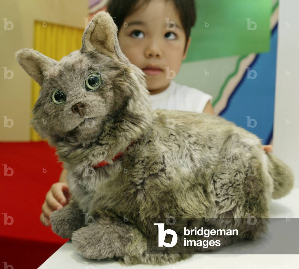 Image of A VISITOR TOUCHES PET ROBOT "NECOT" AT JAPAN TOY SHOW