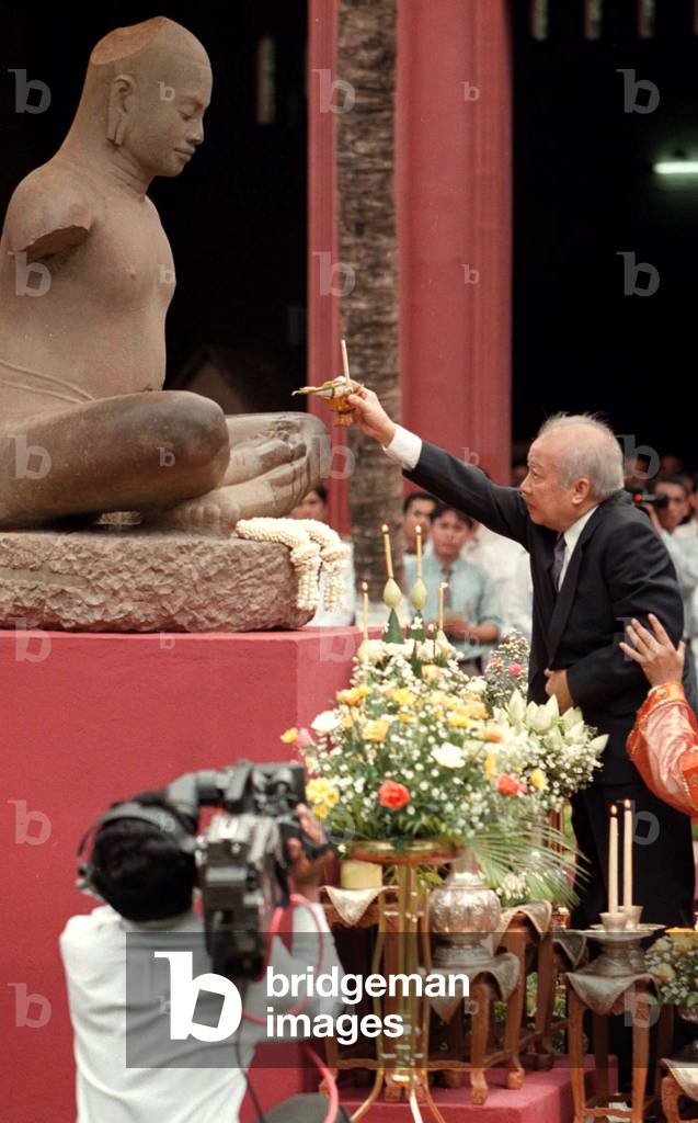 Image of Cambodia's King Norodom Sihanouk blesses a statue of the great