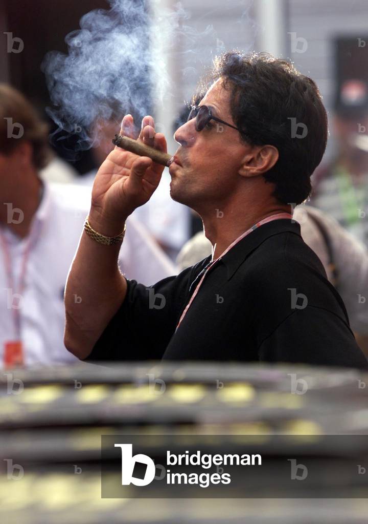 Image of AMERICAN ACTOR SYLVESTER STALLONE SMOKES A CIGAR AT THE HUNGARIAN