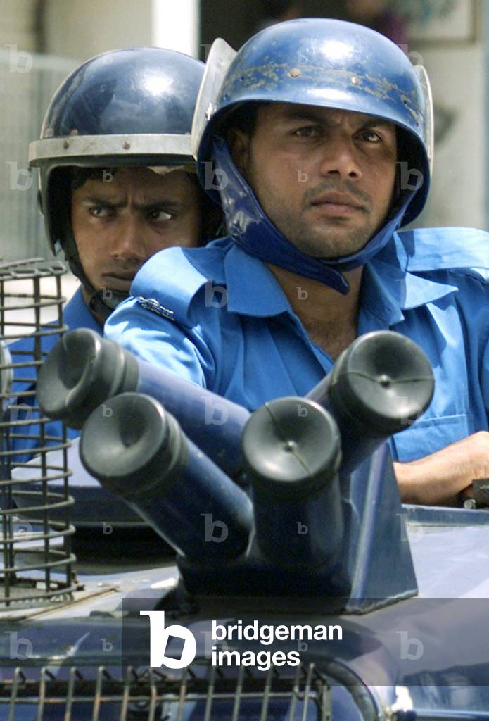 Image of Bangladeshi riot police, standing behind teargas launchers ...