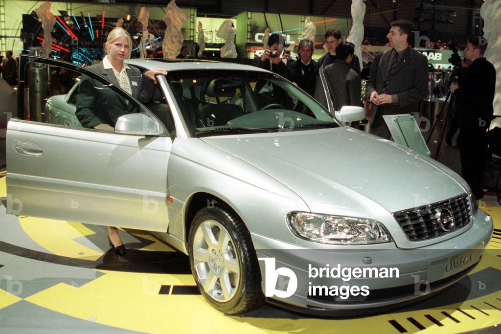 Visitors look at the new Opel Omega V8 displayed at the Geneva International Car Show February 29. T.., 2000-0