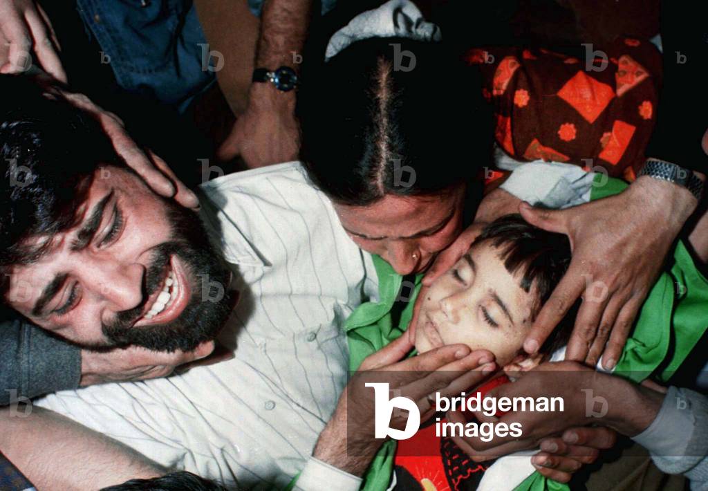 Image of Relatives mourn over the body of five-year-old girl Bushra, who