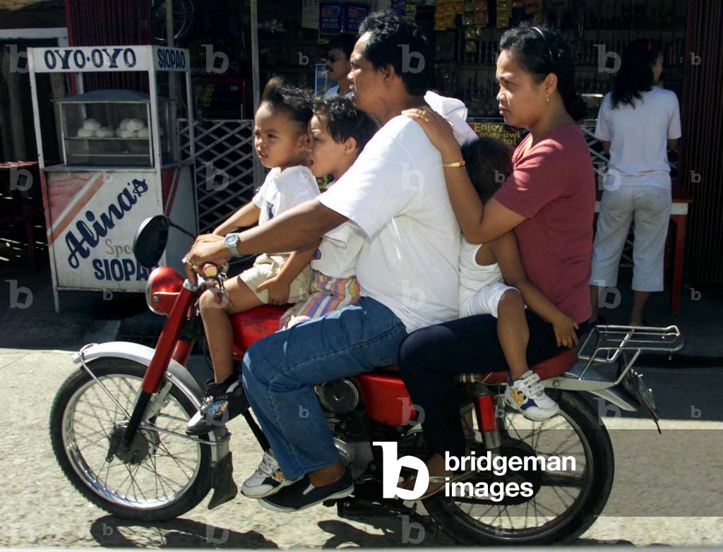 Pinoy Rides Image of A Filipino family of five rides on a small motorbike